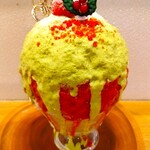 京氷菓 つらら - 氷にイチゴシロップがかけられ、その上から黄緑色したピスタチオシロップ、上にイチゴ、クリスマスプレート、クリスマスホーリー(セイヨウヒイラギ)が添えられ、赤い粉、粉糖がかけられている～!!( ^o^)ﾉ