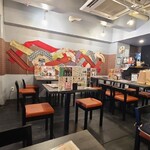 和牛コウネ専門店 いろはうた - 店内は灰色の剥き出しコンクリート天井、簾を帯で貼り和風の装飾を施した灰色のコンクリート壁、焦茶色の木板張り床、外国人向けの和の趣きぽい空間、BGMはJAZZ