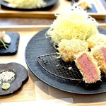 揚雫 - 満を持して、トンカツの登場です。 予約では、TOKYO X ヒレ120ｇをオーダーしてましたが、当日はどうやら入荷が困難だったようで、別のブランド豚のヒレを135gで提供いただきました。 美しい木製のトレーに料理の色が際立つ黒い皿に乗った白いトンカツ。 気高さすら漂います。 縦に走る艶々の筋繊維が見事です。