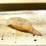 鮨 西崎 - 牡丹海老は、しっかりした脱水によって、まるで寝かせたようなねっとり食感。
      中には、焼いてから砕いた殻と味噌が入っていて、濃厚な味わいの一カン。