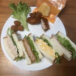 サフラン  - ランチBOXの中身。具沢山で食パン4枚使われてます。2人で食べても良いですね。フライドチキン、丸いハッシュポテト、オレンジケーキとレタスが付いてます。