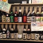 一将丸 - 飲み放題の日本酒と焼酎が並べられている棚。