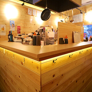 カウンター席中心。木の温もり溢れるアットホームな雰囲気の店内