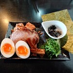 麺坊 ひかり - 先行して全部載せの具材の皿が提供
            
            白髪ネギ、姫みつば→九条ネギに仕様変更されている
            漆黒の竹、炭火焼豚1枚、味玉1個
            炭火焼刻み焼豚ハーフ（3、4個）
            焼海苔、大判海苔2枚、味変用:黒バラ海苔（小）