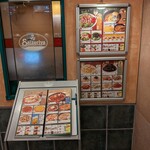 サイゼリヤ - 店舗出入口付近にメニュー冊子が台座に置かれていて、ダイジェスト版メニュー表も壁に取り付けられています。