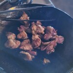 炭焼地鶏 山蔵 - 地鶏のタレ焼きを焼いて、途中に皿に移して小さくカットしました