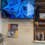 紬生 食堂カフェ - カウンター前の大きなモニターには　タチウオ漁の様子が投影(2025年12月6日撮影)