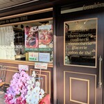 ガトー・ド・ボワ - 黄綬褒章を祝う贈花の上には年末年始のケーキ予約案内