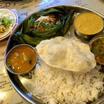 ケララバワン - バナナリーフの中の魚カレーと、サンバル(左)と野菜カレー(右奥)にラッサム(小250円、右手前)を追加しました。