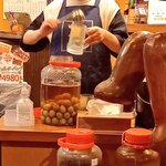 ランサーン - お店の方がラオラオ梅酒をグラスに注いでいるところです。