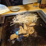 月島もんじゃ おこげ - せせりを鉄板に広げるところまでは店員さんがやってくれる　もやしは自分らで鉄板へ