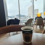 タリーズコーヒー - 店内は白い天井、ガラス張り壁、木板張り床、広島駅を上から眺める事が出来る開放的な空間、BGMはJAZZ