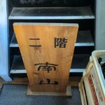 南山 - 2階にある木製の看板