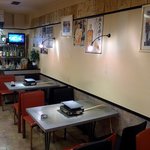 やなちゃん - こっちが普通のテーブル席です。少し小さめのテーブル席です。２人ならここでも十分なスペースがあると思いますよ。壁には沢山の色紙が貼ってありますね。