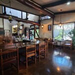 亜林湖 - 淡いクリーム色の天井、木梁、レースカーテンが設置された沢山のガラス窓、絵画の飾られたクリーム色の壁、木柱、木板張り床、漫画の本棚、凝った意匠のペンダント照明、山小屋感のあるロッジ風の空間、BGMは無し