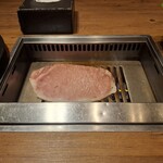 焼肉うしごろ - 網の鉄板の上で、鹿児島県産の大判サーロインを焼く様子のその1です。
