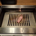 焼肉うしごろ - 網の鉄板の上で、鹿児島県産の厚切りサーロインを焼く様子のその1です。