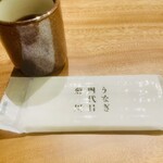 うなぎ四代目菊川 - ブランド名入りのおしぼりと温かいお茶の組み合わせ。ひと口目のほっとする瞬間。
