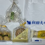 秋田犬の里 お土産コーナー - 一口明がらす 324円　ハチ公くん3個セット 552円　ハチ公作作サブレ3枚セット 324円　煉屋ミニバナナ 151円　レジ袋5円