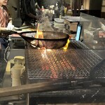 肴や だんじ - 地鶏の炭火焼きを豪快な炎で調理するのを眺めるのも楽しい。