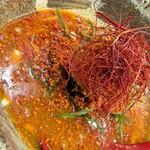 たけ虎 - レッドホットスパイシーラーメン(1辛)近景。大量のブランド唐辛子が浮いてるが、スープのベースがかなり美味しいので、旨味を損なわない仕様。