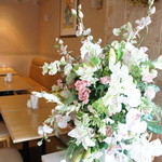 喫茶フルール - 窓の際の席と、奥の席を仕切る生け花