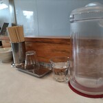 RAMEN TSUKEMEN YAMATO - 卓上 調味料以外には、レンゲ、割り箸、コップ、水のポットが置かれています