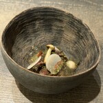 レヴォ - 深みのある器の中央に、薪火で焼かれた月ノ輪熊の赤身が静かに佇みます。