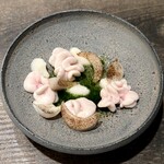 レヴォ - 灰色の陶器皿の上にふっくらと並ぶ白子は、表面にわずかな火が入り、中心はほぼ生のまま。艶やかで柔らかな質感が、見るだけでクリーミーさを伝えてきます。周囲には百合根が花びらのように散りばめられ、ところどころに焦がした柚子の粉が舞うように添えられています。中央には蕪のピューレが淡い緑のソースとして広がり、白と淡緑、焦げ茶の粒子が冬の森の静けさを思わせる佇まいをつくり出しています。