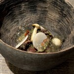 レヴォ - 表面には香ばしい焼き目が入り、中心はしっとりと赤みを残した火入れ。その下には熊の骨からとったコンソメのジュレが淡く広がり、命の記憶が静かに器を満たします。