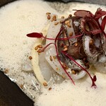 レヴォ - その隣には同じく細切りにされたマコモダケが寄り添います。全体を包むようにアサリの泡ソースがふんわりと広がり、貝の旨みと生クリームのなめらかさが視覚にも柔らかさを与える。仕上げの金ゴマが香ばしさと輝きを添え、細切りという統一された造形が素材の個性を際立たせています。