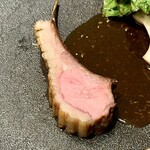 レヴォ - 肉の下には猪・鹿・熊を合わせた濃厚なジビエソースが静かに広がり、深い褐色が皿に重厚な余白を生みます。