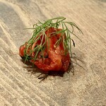 レヴォ - 左側には燻製されたトマトが小さく盛られ、赤の艶とスモーキーな香りが皿にアクセントを添えます。