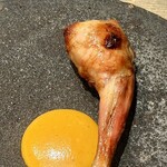 レヴォ - 内部には月ノ輪熊の油と内臓の出汁、鶏の出汁で炊き上げたうるち米が詰められ、命の記憶が肉の中に静かに宿ります。中央には和がらしのソースが一筋添えられ、黄色の光が香りに緊張感を与える。器の黒と肉の黄金、ソースの黄が響き合い、構造・香り・視覚すべてが主役の風格を備えています。