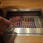 焼肉うしごろ - 網の鉄板の上で、北海道産の大判サーロインを焼いている様子のその3です。