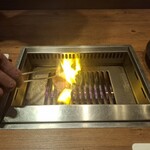 焼肉うしごろ - 塩ダレのトモサンカクとリブ芯のいずれか残り1枚を、網の鉄板の上で焼く様子のその1です。