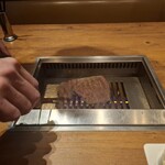 焼肉うしごろ - 網の鉄板の上で、北海道産の大判サーロインを焼いている様子のその2です。