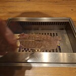 焼肉うしごろ - 網の鉄板の上で、北海道産の大判サーロインを焼いている様子のその5です。
