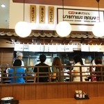 MARUGAME SEIMEN - 水曜日のお昼時はほどよく混雑、お客さんが楽しそうに並んでいます。