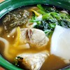 無添くら寿司 - 天然ふぐ出汁うどん（610円）白くて四角いのはカマボコ、緑はほうれん草、それとおぼろ昆布＋ゆず