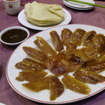 天厨菜館 - ダックちゃんのパリパリの皮、甜メン醤、ネギをできたての温かい焼餅（シャオピン）で巻いていただきます。 早く食べないと胸焼けしてしまいますのでガツガツいきます。幸せ～♪ 焼餅、甜メン醤、ネギまでサービスでたくさん頂けます。言わないとたくさんは貰えません