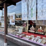 おかき処　虎笛 - 木枠の大きな窓には雛人形が飾られて