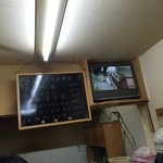 臚雷亭 - 本日のオススメとテレビ。ソロ活動のお客さんもじっと見入っています。