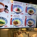 MARUGAME SEIMEN - メニュー。かけうどん69バーツには、野沢菜のトッピングが標準です。タイ人にはすうどんの絵柄が寂しいのでしょう。