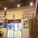 浜小屋 - 壁には、漁師から贈られた大漁旗やメッセージが何枚も貼られている