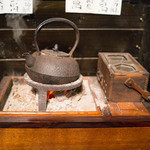 粥茶屋 写楽 - テーブル席には鉄瓶の暖房