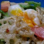Salad with mizuna and lotus root chips topped with warm egg