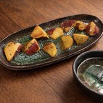 無名塾 - 熱々！大学芋
熱々の大学芋を氷水にくぐらせ、表面の飴をキュッ！と固めた一品。パリッとした飴の食感と、中のホクホク甘いさつまいものコントラストがたまらない大学です。
