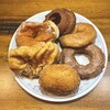 HAPPY DONUT - 料理写真:戦利品を皿に並べてみた。手前はカレードーナツ※一般名カレーパン(^^) 実はこの後も皆んなですごい量の買い物をしたのでドーナツ箱が潰れてしたいました