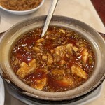 随園別館 - 「グツグツと土鍋で煮込まれた麻婆豆腐」 甘い黒豆の様な物が気になって、相方に言ったら 中華調味料「豆豉（トウチ）」だろうと教えられた 辛さも旨味もこんなところにあるのだろう 久しぶりに美味しい麻婆豆腐に出会えました。